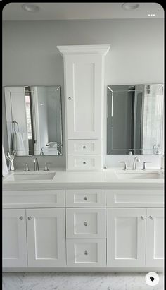 a white bathroom with double sinks and mirrors