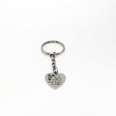 a heart shaped keychain with a dog's paw print on the front