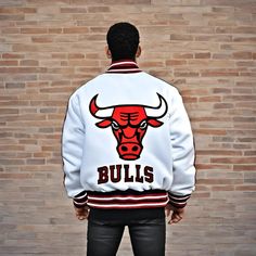 Men’s Chicago Bulls Letterman Jacket The Bulls varsity jacket is not just your regular outerwear, it's a fashion statement that combines comfort and style seamlessly. Crafted from high-quality Melton wool for the body and white cowhide leather for the long sleeves, this jacket guarantees a soft and lightweight feel, making it the ideal choice for both indoor and outdoor casual wear. Product Specification Material Body: Premium Quality Melton Wool Sleeves: Genuine Cowhide Leather Rib: 100% Cotton Lining: Quilted Diamond Lazer (100% Polyester) Snap Button: Easy to Fasten Logos: Chenille with Felt Bottom Pockets Two Large Outer pockets with zipper Two Inner deep pockets Helpful Details:We can start your consultation with whatever details you have. If you already have some thoughts from the fo White Baseball Collar Outerwear For Sports Events, Urban Style Varsity Jacket With Baseball Collar, Urban Outerwear With Baseball Collar For Sports Events, Throwback Long Sleeve Varsity Jacket For Sports Events, Casual Fall Varsity Jacket For Sports Events, White Baseball Collar Track Jacket For Fall, White Fall Track Jacket With Baseball Collar, White Varsity Track Jacket For Winter, White Track Jacket With Baseball Collar For Fall