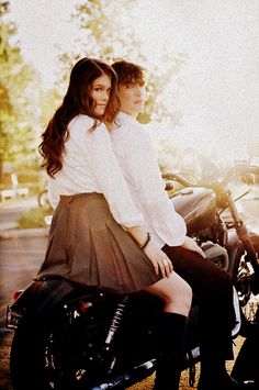 a man and woman sitting on a motorcycle