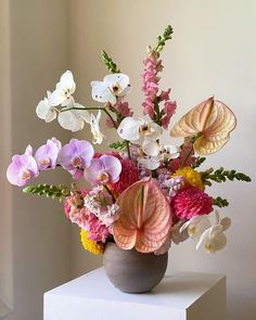 a vase filled with lots of different colored flowers