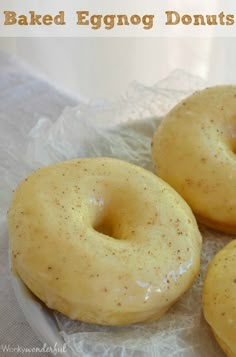 three glazed donuts sitting on top of a piece of wax paper