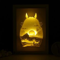 the paper cut art is displayed in front of a dark background with an image of a cat