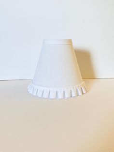 a white lamp shade sitting on top of a table