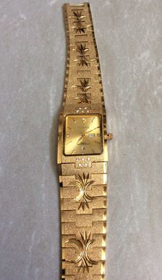 Sunborn men's high quality water resistant watch, having a gold rectangle dial, displaying gold index hoursand having a day and date indicators at the third and sixth hour position, all on a engraved gold designedlinked band. this is a unused still new vintage watch, ready to keep you up with accurate time. this is a water resistant watch and would make anawesome gift item. measurements: bezel/case  1 1/8" x 7/8" rectangle, dial 7/8" x 3/4" rectangle, band width 7/8" and fits a standard 8"wrist perfectly. if a smaller wrist size is needed, we offer free custom sizing. prior to purchasing, please message us for details needed for the free sizing process. we ship fast, the next business day, for a quick delivery to you. may you have a wonderful time shopping, best wishes! Luxury Vintage Watch With Date Indicator, Gold Rectangular Watch Accessories For Formal Occasions, Gold Watches With Date Display And Rectangular Dial, Gold Rectangular Watches With Subdials, Gold Watches With Rectangular Metal Dial, Gold Watch Accessories With Date Display For Gift, Rectangular Gold Watch Accessories For Gift, Rectangular Metal Dial Watch For Anniversary, Rectangular Watches With Date Display