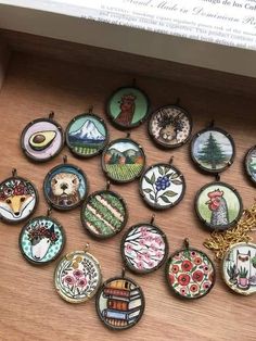 a bunch of different designs on some kind of brooches that are hanging from a shelf