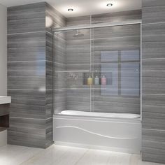 a bathroom with a glass shower door and tiled walls