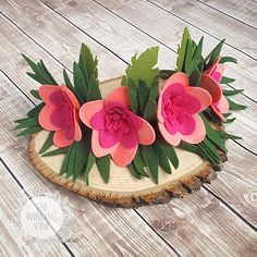 some pink flowers are sitting on a piece of wood