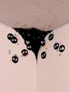 there are many little black sheep hanging from the ceiling in this room with white walls