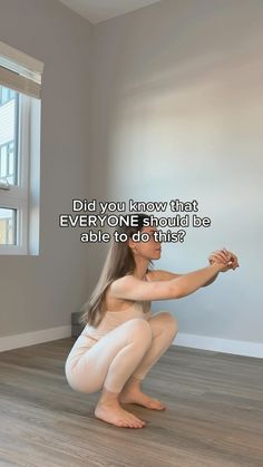 a woman kneeling on the floor in front of a window with an inspirational quote above her