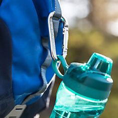 a blue backpack with a water bottle attached to the back of it's shoulder