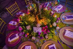 the table is set with purple and gold plates, napkins, and place settings