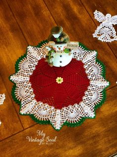 a crocheted doily with a teddy bear on it