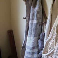 several towels hanging on a wall next to a crochet hook