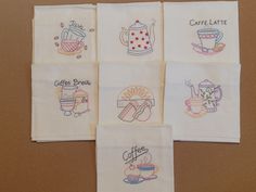 four embroidered napkins with coffee related designs on them, all in different shapes and sizes