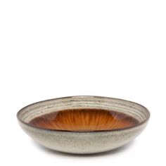 a brown and white bowl sitting on top of a table