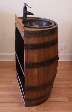 a wooden barrel sink with a faucet on it's side next to a wood floor