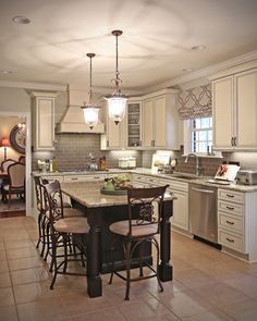 a large kitchen with an island in the middle and lots of chairs at the table