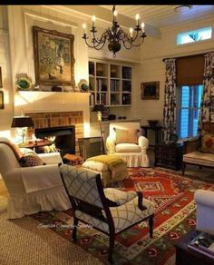 a living room filled with lots of furniture and a chandelier hanging from the ceiling