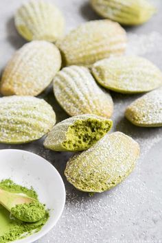 pistachio cookies with powdered sugar on them and a bowl of pesto