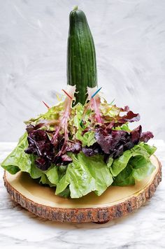 a wooden slice with lettuce and other vegetables on it