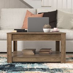 a coffee table with books and a laptop on it