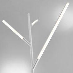 a white lamp with two sticks sticking out of it's sides on a gray background