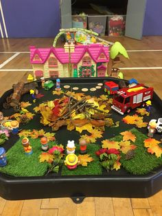 a play area with toys and fake leaves on the floor