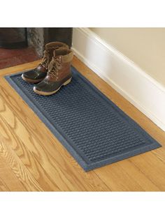 a pair of boots sitting on top of a blue mat next to a fire place