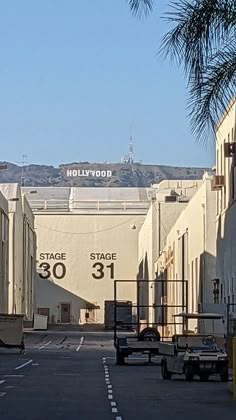 an empty parking lot in front of the hollywood sign and building with mountains in the background