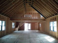 an empty room with wooden walls and beams on the ceiling is seen in this image