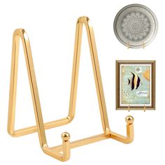 a gold metal shelf with two hooks and a picture frame