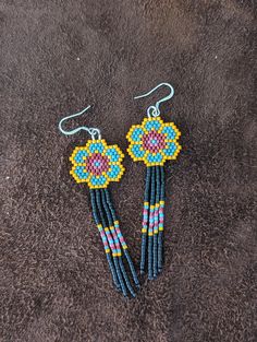 the beaded earrings are made with blue and yellow beads, which have flowers on them