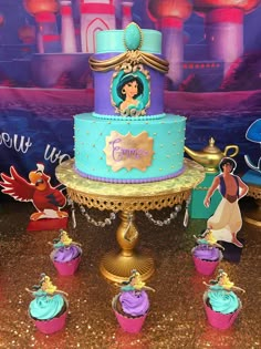 there are many cupcakes on the table next to this cake and it is decorated with princesses