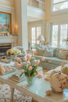 a living room filled with lots of furniture and flowers on top of a coffee table