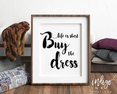 a framed poster with the words life is short buy the dress in black on it