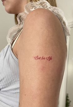 a woman with a tattoo on her arm that says bad for life in red ink