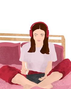 a woman with headphones sitting on a bed