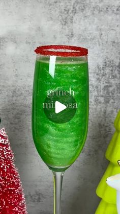 a green wine glass sitting on top of a table next to other christmas tree decorations