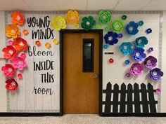 a door with paper flowers on it and a sign that says young minds bloom inside this room