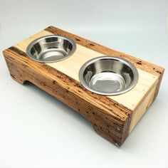 two stainless steel dog bowls in a wooden box on a white surface with the lid open