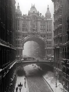 an old black and white photo of people walking in the snow