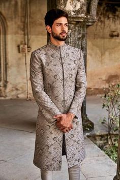 Grey sherwani featuring floral jaal motif heavy zardozi embroidery. Paired with churidar.
Component: 2
Pattern: Embroidered
Type Of Work: Zardozi
Neckline: Band Collar
Sleeve Type: Straight Full
Fabric: Raw Silk, Silk
Color: Grey
Other Details: 
Front slit sherwani
Floral jaal motifs
Note: The kurta-bundi set worn by the model on the right is not for sale
Occasion: Wedding - Aza Fashions Grey Sherwani, Embroidered Sherwani, Groom Dress Men, Indian Groom Wear, Sherwani Groom, Mens Sherwani, Jayanti Reddy, Zardozi Embroidery, Indian Groom