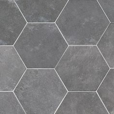 a tile floor with hexagonal tiles in grey and white colors on the surface