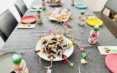 a table set up with plates, cups and candy on it for a birthday party