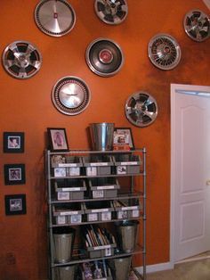 a room with orange walls and lots of silver plates on the wall, along with other metal objects