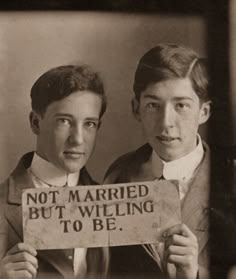 two young men holding up a sign that says not married but welling to be