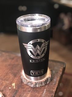 a stainless steel yeti cup sitting on top of a wooden table