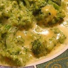 broccoli covered in cheese and sauce on a plate