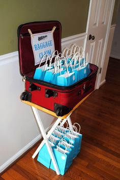 a red suitcase with blue bags in it sitting on top of a wooden floor